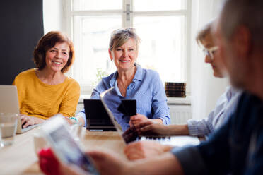 Group of senior people using laptops and tablets in community center club, technology in everyday life concept. - HPIF25789