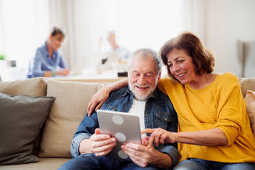 Ein älteres Ehepaar benutzt ein Tablet in einem Club im Gemeindezentrum, Technologie im täglichen Leben. - HPIF25790
