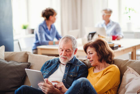 Gruppe älterer Menschen, die Laptops und Tablets in einem Gemeindezentrum benutzen, Konzept der Technologie im täglichen Leben. - HPIF25794