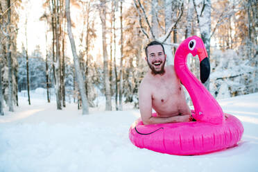 Ein Porträt von oben ohne jungen Mann im Freien im Schnee im Winter Wald, Spaß haben. - HPIF25933