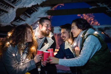 Eine Gruppe junger Freunde, die nachts im Schnee unterwegs sind und Wunderkerzen halten. - HPIF25950