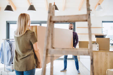 Ein junges glückliches Paar, das ein neues Haus einrichtet, ein Konzept für den Einzug in ein neues Zuhause. - HPIF25987