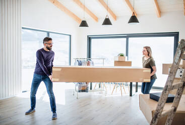 A young happy couple furnishing new house, a moving in new home concept. - HPIF25989