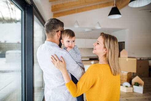 Eine glückliche junge Familie mit einem kleinen Mädchen zieht in ein neues Haus ein. - HPIF26056