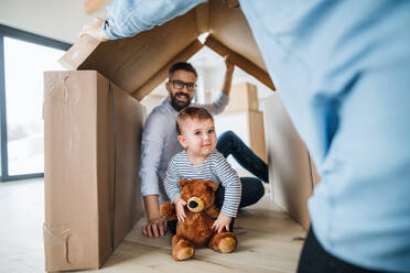 A portrait of happy young family with a toddler girl, moving in new home concept. - HPIF26060