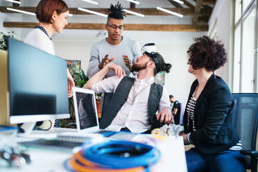 Eine Gruppe junger Geschäftsleute mit VR-Brillen, die sich im Büro unterhalten, Start-up-Konzept. - HPIF26086
