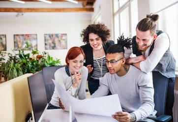 Eine Gruppe junger Geschäftsleute, die in einem Büro arbeiten, Start-up-Konzept. - HPIF26138