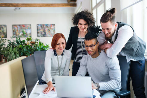 Eine Gruppe junger Geschäftsleute mit Laptop, die im Büro arbeiten, Start-up-Konzept. - HPIF26140