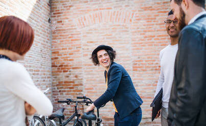 Eine Gruppe junger Geschäftsleute mit Fahrrädern im Innenhof, die sich unterhalten - ein Konzept für ein Start-up. - HPIF26179