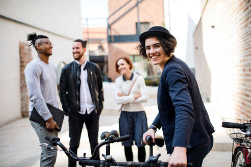 Ein glücklicher junger Geschäftsmann mit Fahrrad, der im Freien steht. Start-up-Konzept. - HPIF26180