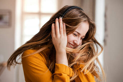 Eine glückliche junge Studentin mit Kopfhörern, die Spaß hat. - HPIF26323