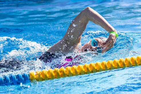 Junger Triathlet übt Schwimmen im Pool - STSF03708