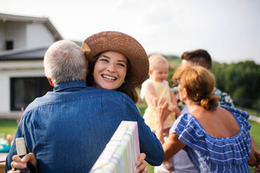 Ein Porträt von glücklichen Menschen im Freien auf einer Familiengeburtstagsfeier. - HPIF26437