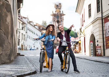 Young tourist couple travellers with electric scooters in small town, sightseeing. - HPIF26579