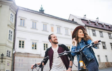 Young tourist couple travellers with electric scooters in small town, sightseeing. - HPIF26584