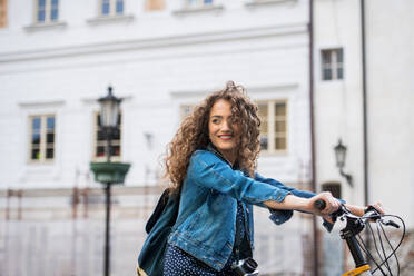 Schöne junge Frau Tourist Reisende mit Elektro-Roller in kleinen Stadt, Sightseeing. - HPIF26596