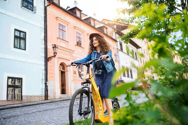 Schöne junge Frau Tourist Reisende mit Elektro-Roller in kleinen Stadt, Sightseeing. - HPIF26599