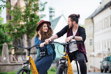 Young tourist couple travellers with electric scooters in small town, sightseeing. - HPIF26601