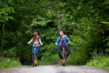 Junges Touristenpaar mit Rucksäcken und Elektrorollern in der Natur unterwegs. - HPIF26618