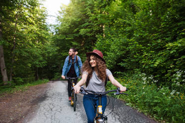 Young tourist couple travellers with backpacks and electric scooters in nature. - HPIF26622