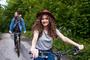 Junges Touristenpaar mit Rucksäcken und Elektrorollern in der Natur unterwegs. - HPIF26623