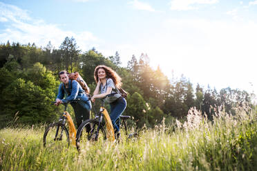 Junges Touristenpaar, das mit Rucksäcken und Elektrorollern in der Natur unterwegs ist und sich ausruht. Raum kopieren. - HPIF26638