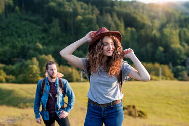 Ein junges Touristenpaar, das mit Rucksäcken in der Natur wandert. - HPIF26648