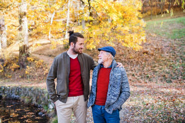 Senior father and his young son walking in nature, talking. - HPIF26699