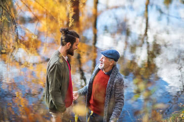 A high angle view of senior father and his son standing in nature, talking. - HPIF26710