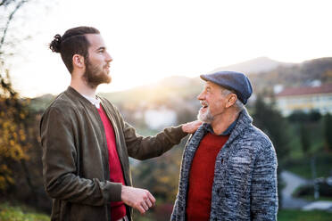 Senior father and his young son on a walk in nature, talking. - HPIF26725