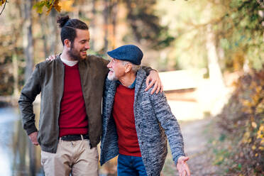 Senior father and his young son walking in nature, talking. - HPIF26755