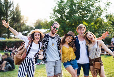 Group of cheerful young friends at summer festival, looking at camera. - HPIF26783