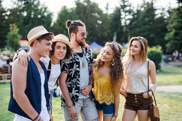 Eine Gruppe fröhlicher junger Freunde auf einem Sommerfest, die sich unterhalten. - HPIF26786