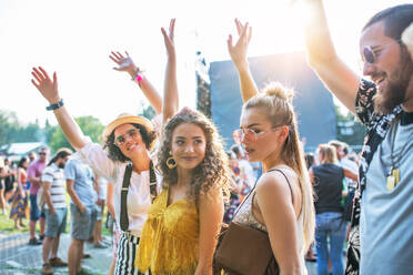 Ein Porträt einer Gruppe junger Freunde, die auf einem Sommerfest tanzen, in der Vorderansicht. - HPIF26809