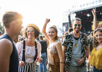 Ein Porträt einer Gruppe junger Freunde, die auf einem Sommerfest tanzen, in der Vorderansicht. - HPIF26812