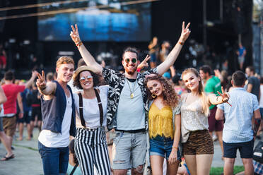 Eine Gruppe fröhlicher junger Freunde auf einem Sommerfest, die in die Kamera schauen. - HPIF26824