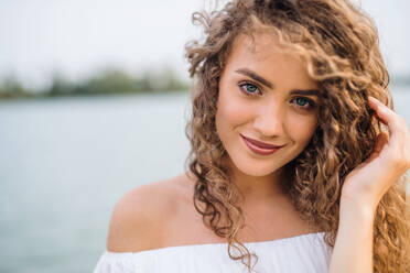 Front view portrait of young woman standing outdoords in summer. Copy space. - HPIF26951