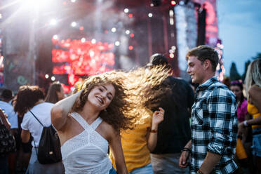 A group of cheerful young friends dancing at summer festival. - HPIF26971