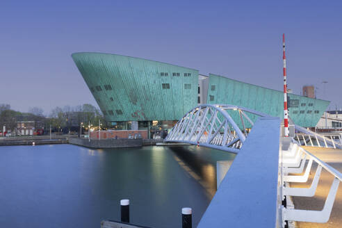 Niederlande, Nordholland, Amsterdam, NEMO Science Museum und Brücke in der Abenddämmerung - FCF02131