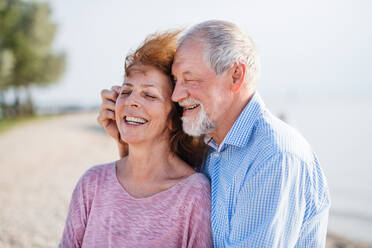 Nahaufnahme eines älteren Paares im Urlaub, das sich beim Spazierengehen umarmt. - HPIF27035
