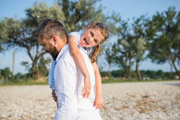 Ein reifer Vater mit seiner kleinen Tochter im Urlaub am See, beim Spazierengehen. - HPIF27041