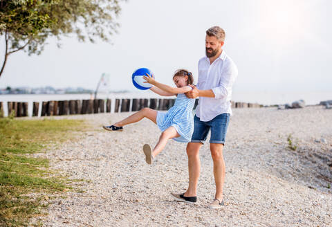 Ein reifer Vater und eine kleine Tochter im Urlaub, die am See oder am Meer spielen. - HPIF27052