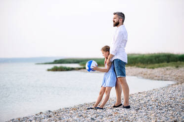 Ein reifer Vater und eine kleine Tochter im Urlaub, die am See oder am Meer spielen. - HPIF27057