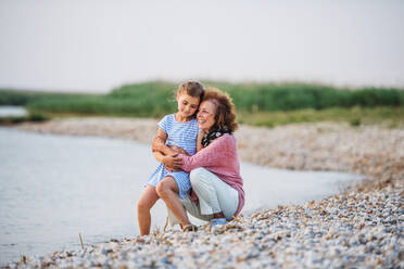 A small girl with grandmother on a holiday by the lake, talking. - HPIF27067