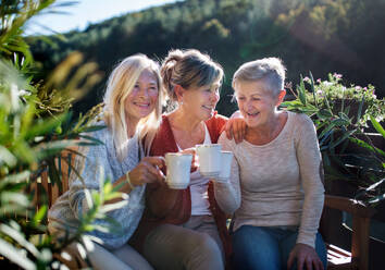 Eine Gruppe älterer Freundinnen sitzt auf einer Terrasse und ruht sich aus. - HPIF27163