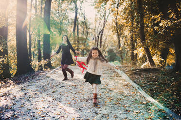 A portrait of young mother with a small daughter walking in forest in autumn nature. - HPIF27457