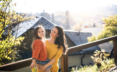 A portrait of young mother with a small daughter walking in park in autumn. - HPIF27469