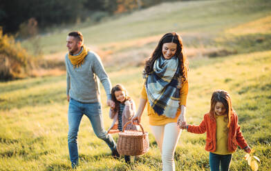 Eine glückliche junge Familie mit zwei kleinen Kindern beim Spaziergang in der herbstlichen Natur. - HPIF27495