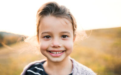 Ein Porträt eines glücklichen kleinen Mädchens in herbstlicher Natur. - HPIF27541