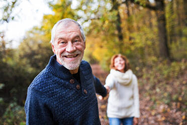 Porträt eines aktiven Seniorenpaares beim Spaziergang in der herbstlichen Natur. - HPIF27563